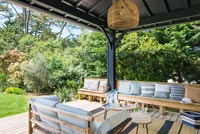 Long banc en bois assis sur une terrasse couverte en bois