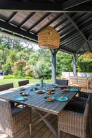 Grande table à manger extérieure sur terrasse couverte
