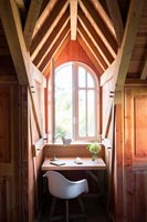 Coiffeuse dans une petite alcôve à côté de la fenêtre d'une chambre en bois