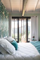 Portes-fenêtres ouvertes dans une chambre moderne avec tête de lit peinte