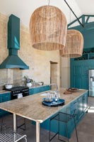 Cuisine de campagne moderne avec boiseries peintes bleu sarcelle et murs en pierres apparentes