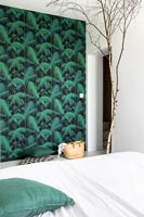 Mur en papier peint vert et ornement de branche d'arbre nu dans une chambre moderne