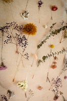 Fleurs séchées affichées sur une tenture en toile de jute