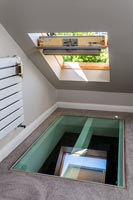 Fenêtre de toit ouvrant dans le toit au-dessus de la trappe en verre dans le sol