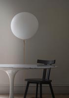 Lampe ballon blanche à côté de la table et de la chaise