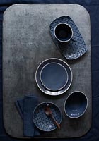 Vaisselle bleu foncé sur table à manger grise