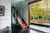 Escalier ouvert dans couloir contemporain avec grande baie vitrée