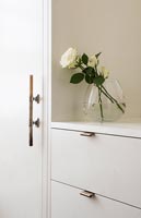 Roses blanches dans un vase sur les meubles de la chambre