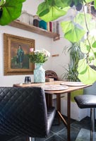 Table pliante dans une petite salle à manger entourée de plantes d'intérieur