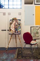 Chevalet avec des illustrations modernes colorées dans un salon éclectique