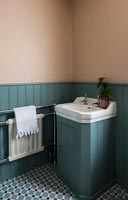 Meuble-lavabo blanc dans salle de bain lambrissée en bois peint bleu