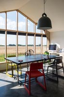 Salle à manger moderne avec mur vitré et vue sur la campagne