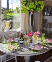 Salle à manger moderne aménagée pour le déjeuner avec des accessoires roses et verts