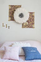 Chambre moderne avec fleur en tissu et photos au-dessus du lit