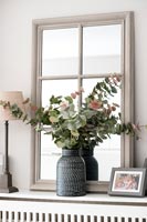 Vase de feuilles et feuillage sur couvercle de radiateur avec miroir