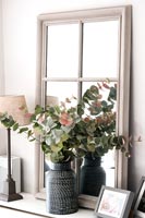 Vase de feuilles et feuillage sur couvercle de radiateur avec miroir
