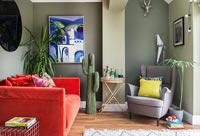 Murs peints en vert et canapé rouge dans le salon moderne