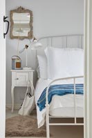 Cadre de lit en métal blanc dans une chambre de campagne