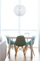 Chaises turquoise autour de la table à manger dans la salle à manger blanche moderne