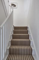 Tapis d'escalier rayé marron sur escalier blanc