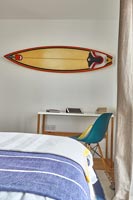 Planche de surf sur le mur de la chambre sur le bureau