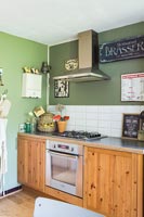 Cuisine de campagne avec armoires en bois et mur peint en vert