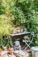 Statue de chien à côté d'une petite table de jardin dans le jardin