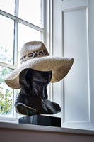Buste noir coiffé d'un chapeau d'été