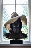 Buste noir coiffé d'un chapeau d'été