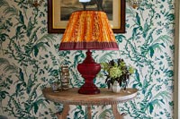 Grande lampe orange sur table console en bois dans le couloir