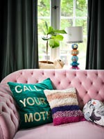 Coussins colorés sur canapé rose