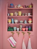 Étagères peintes en rose contre un mur peint en rose dans une cuisine moderne