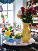 Vase jaune de dahlias sur plateau rose