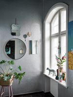 Ornements sur le rebord de la fenêtre de la salle de bain avec des murs argentés