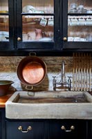 Grand évier en béton dans une cuisine de campagne peinte en noir
