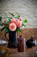 Arrangement de fleurs en pot noir sur la table à manger country