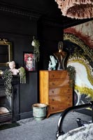 Commode vintage en bois dans une chambre éclectique peinte en noir