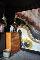 Mur d'éléments peints et commode vintage en bois