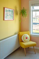 Fauteuil jaune dans un salon moderne avec des murs peints de couleurs vives.