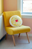 Coussin à motifs de cœur sur une chaise jaune moderne