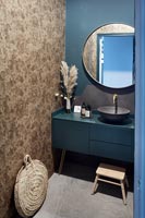 Salle de bain peinte en bleu avec mur de mosaïque en pierre