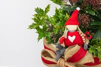Figurine nordique en arrangement de Noël avec Holly et Skimmia