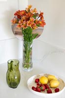 Vase de fleurs et bol de fruits