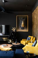 Murs peints en noir dans un salon moderne avec un mur d'or et une tête de trophée en tissu Rhino