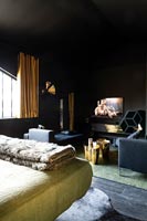 Chambre moderne avec murs peints en noir et accessoires dorés