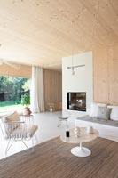 Salon en bois moderne avec vue sur le jardin par des portes pliantes ouvertes