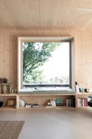 Grande baie vitrée carrée dans un salon moderne revêtu de bois