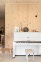 Piano droit blanc dans la salle de musique en bois moderne