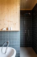Carrelage noir et revêtement en bois dans la salle de bains moderne