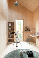 Chambre d'enfants moderne revêtue de bois avec télescope et bureau